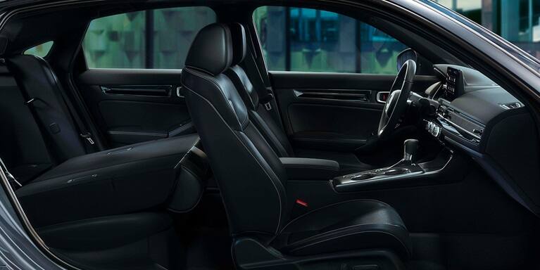 2027 Honda Civic Hatchback Touring Hybrid leather-trimmed seats with rear seat folded down (Compact Hatchback).